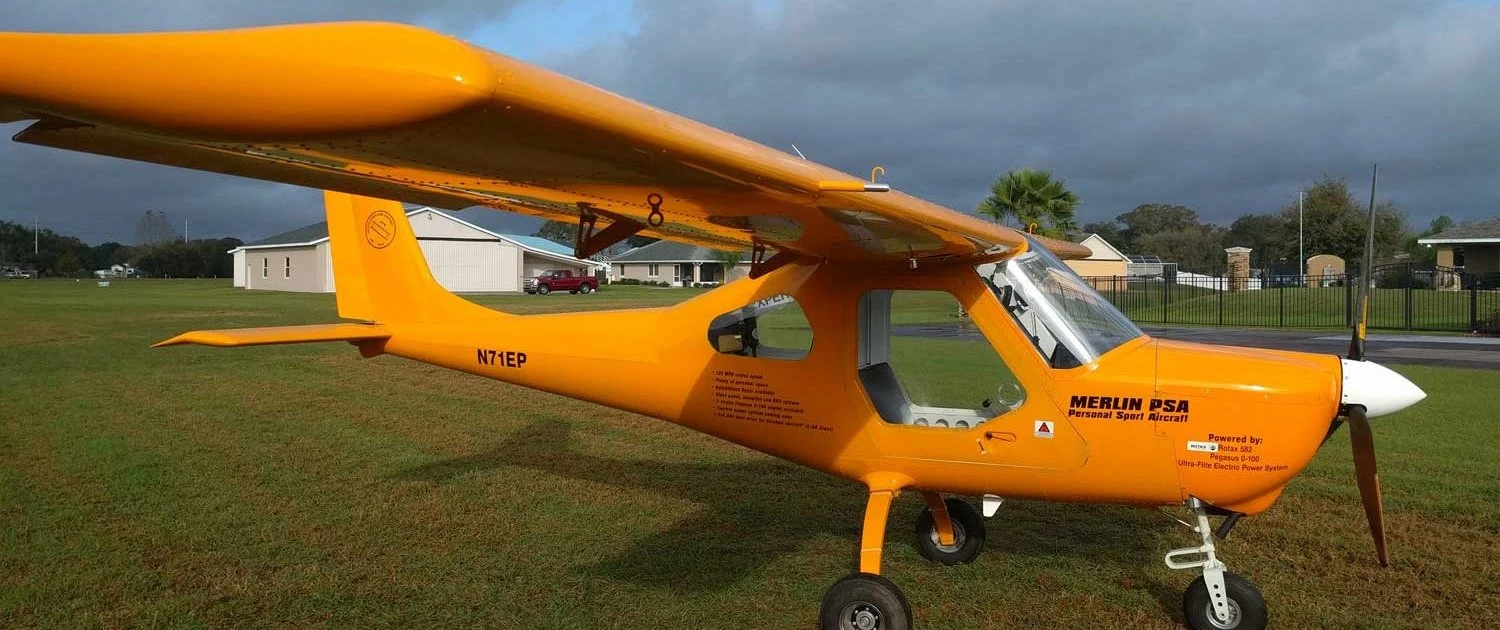 Yellow TechPro Merlin parked on a grass airfield